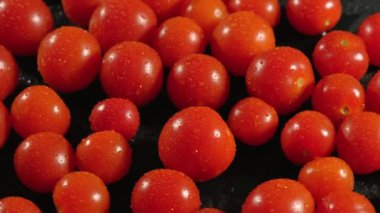 Kırmızı kiraz domatesleri mutfak masasında yavaşça döner. Sağlıklı gıda konsepti.