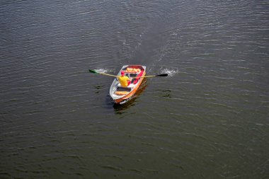 Bir teknede cankurtaran, nehirde kürek çekiyor. Yukarıdan görüntüle.