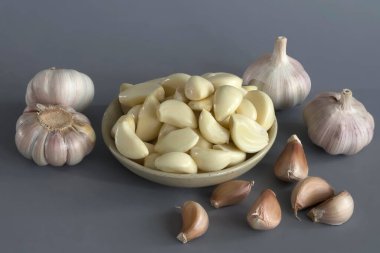 Gri arka plandaki tabakta sarımsak hasat et. Sarımsak masada..