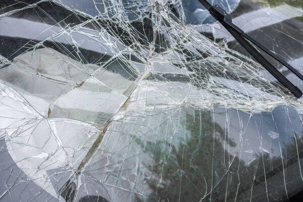 The broken windshield in car accident. Beaten frontal glass.