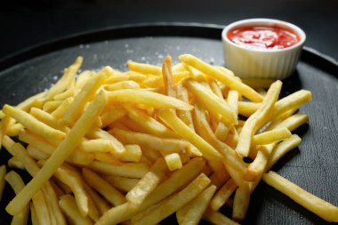 Koyu arkaplanda patates kızartması, yakın plan. Fast food.