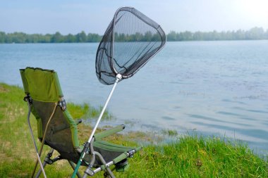 Nehirde balıkçılık malzemeleri. Sandalye, kelebek ağı, balıkçılık geçmişi.
