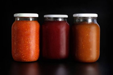 Siyah arka planda sebze turşusu. Cam kavanozlarda muhafaza ediliyor. Konserve sebze malzemeleri..