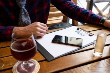 Alkolizm konsepti. Masadaki barda tek başına bira içen sarhoş ve işsiz bir adam. Alkol bağımlılığı ve depresyonla mücadele