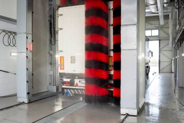 Deterjanlı yüksek basınçlı su kullanan otomatik yıkama yapan bir kamyon. Kamyonları temiz tutmak. Araba servisi..