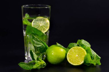 Siyah arka planda mojito limonata. Limonlu, limonlu ve naneli.
