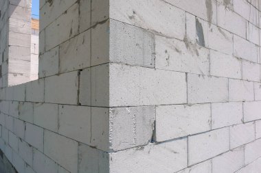 Havalı beton bloktan yapılmış beyaz bir duvarın köşesi. Yapı kavramları.