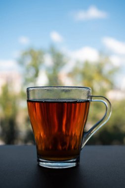 Pencerenin yanında cam bir bardak kokulu çay duruyor..