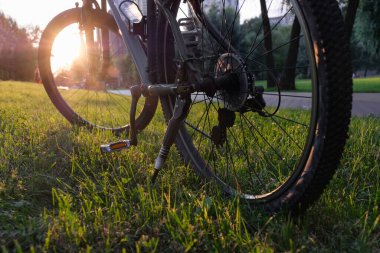 Gün batımında bir şehir parkında yakın çekim bisikleti. Etkin yaşam tarzı kavramı.