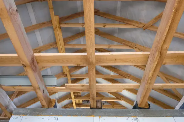 stock image Wooden roof structures of a new residential building. Unfinished brick building under development.