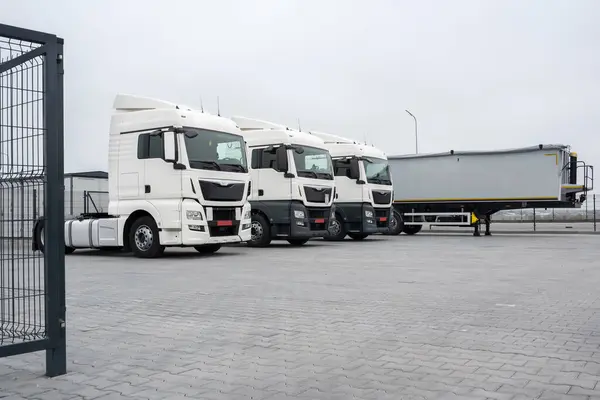 Trucks with cargo trailers in the parking lot, Freight transport by road, Logistics and cargo transportation concept.