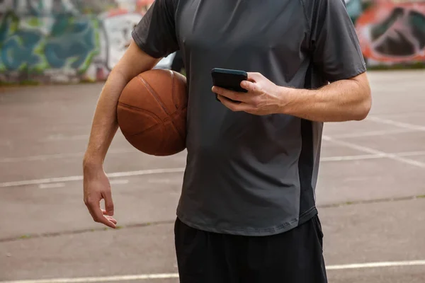 Баскетболист Мячом Телефоном Руках Открытой Баскетбольной Площадке — стоковое фото