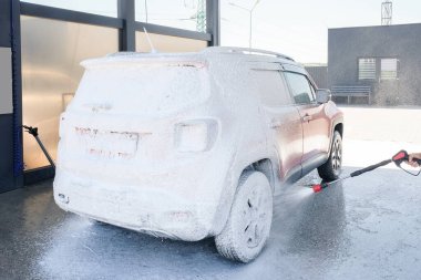 Araba yıkama yerindeki köpüklü araba. Yüksek basınçlı sabunla araba yıkama.