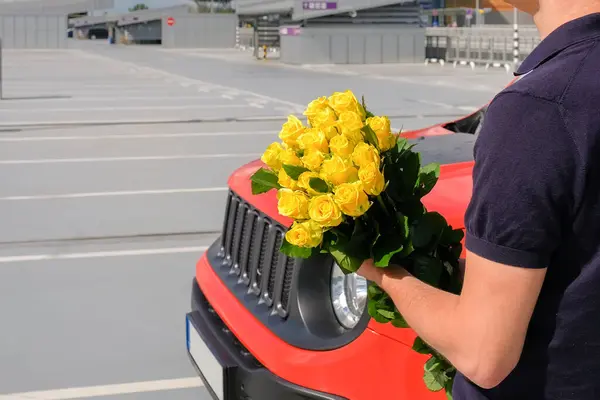 在停车场里拿着一束花的男人 — 图库照片