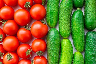 Masanın üstünde taze domates ve salatalık var. Organik ürünler, sebzeler.