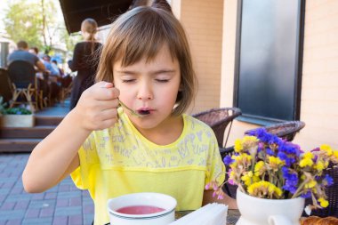 Küçük kız kahvaltını kafede yapıyor..