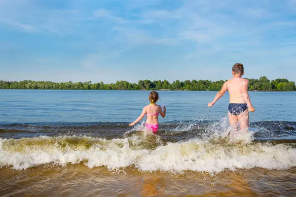 Güneşli bir yaz gününde sahilde oynayan mutlu çocuklar. Yaz tatili