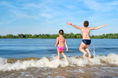 Yaz mevsiminde, çocuklar nehrin kıyısında oynarlar. Bir arka plan.