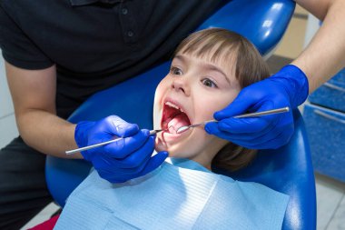 Diş hekiminde hastaların dişlerini muayene eden bir dişçi..