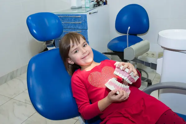 Bir çocuk diş hekimlerinde plastik çene taklidi yapıyor..