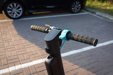 Şehirdeki bir otoparkta elektrikli bir scooter park halinde. Ekolojik nakliye. Kentsel yaşam tarzı.