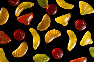 Siyah arka planda reçelli şekerler. Meyveli şekerlerin yakın çekimi, üst görünüm..