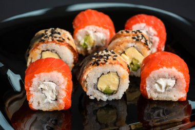 Geleneksel suşi siyah arka planda yuvarlanır. Japon yemeği..