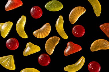 Siyah arka planda jöle renkli jöle şekerler, üst görünüm.