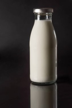 Siyah arka planda bir şişe taze süt. Süt ürünleri