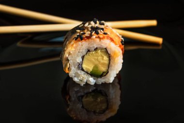 Siyah arka planda geleneksel suşi rulosu. Japon yemeği..