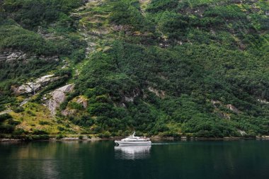 Motorlu yat, tropikal yeşil bir manzaranın arka planında. Seyahat kavramı