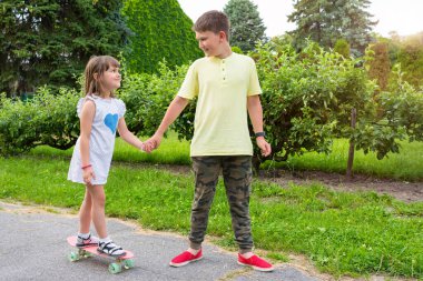 Çocuklar güneşli bir yaz gününde parkta oynarlar..