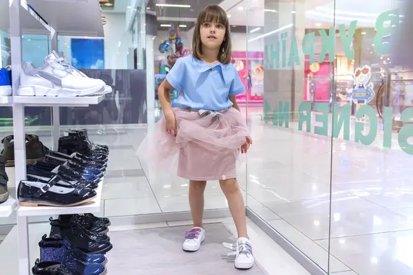 A girl measures shoes in a shopping center. Shopping, discounts.
