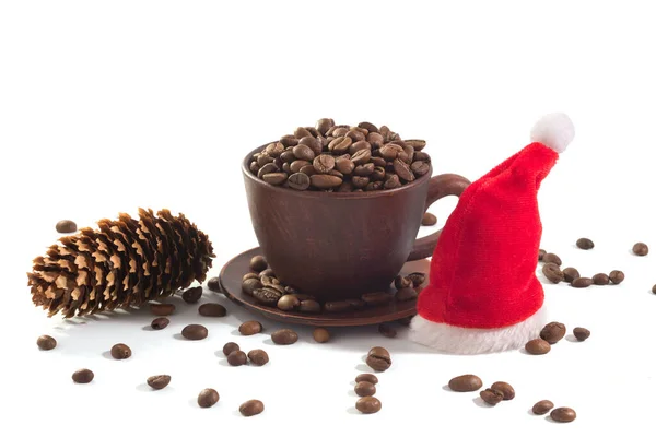 Cup with coffee beans and New Year\'s hat on a white background. On the eve of the New Year and Christmas.
