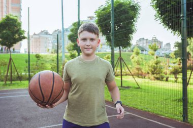 Basketbol topu olan bir çocuk, şehir kortunda. Spor yaşam tarzı..