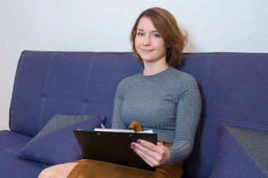 Ofisteki koltukta psikoterapi gören genç bir psikoloğa danışıyorum. Psikolog hastayla bir seans yapıyor..