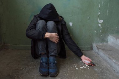 Uzun süre uyuşturucu ve alkol kullandıktan sonra uyuşturucu bağımlılığı krizi geçiren bir erkek uyuşturucu bağımlısı. Bağımlılık ve uyuşturucu bağımlılığı kavramı.