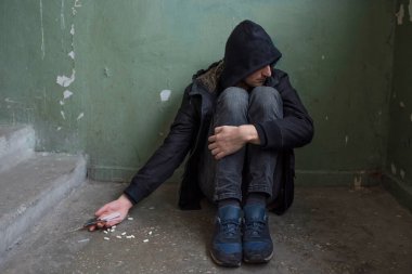 Bağımlılık konsepti. Terk edilmiş bir evde kriz geçiren bir bağımlı. Aşırı doz, uyuşturucu bağımlılığı..