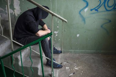 Terk edilmiş bir evde uzun süre uyuşturucu kullandıktan sonra uyuşturucu bağımlılığı krizine girmiş. Bağımlılık kavramı.