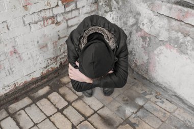 Terk edilmiş bir evde uyuşturucu ve alkol kullanan bir genç yalnız oturur. Bağımlılık kavramı.