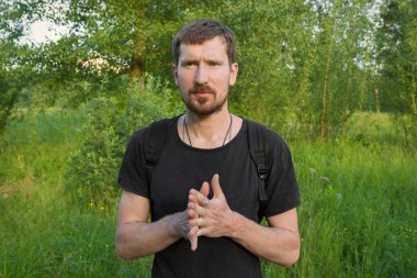 Yaz parkında sakallı bir gencin portresi..