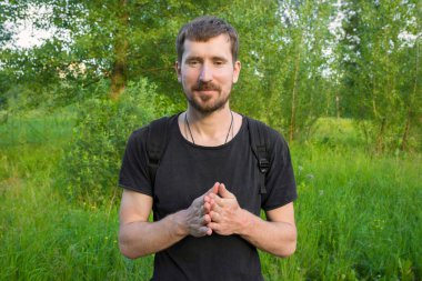 Güneşli bir yaz gününde parkta sakallı genç bir adam. Parkta dinleniyor..