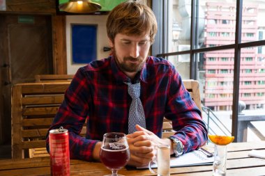 Yalnız ve işsiz bir adam bir masada bir barda oturuyor. Alkolizm ve alkol bağımlılığına karşı mücadele, kriz, depresyon. Yaşam biçimi.