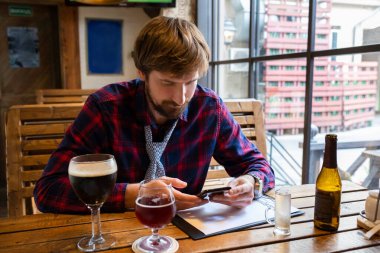 Üzgün, mutsuz, işsiz bir adam barda tek başına oturmuş içki içiyor. Alkolizm, alkol bağımlılığı