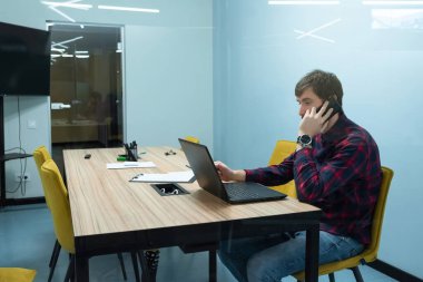 Genç işadamı masasında çalışıyor..