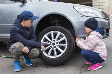 Oğlan ve kız araba servisinde. Araba tamiri, tamirat..