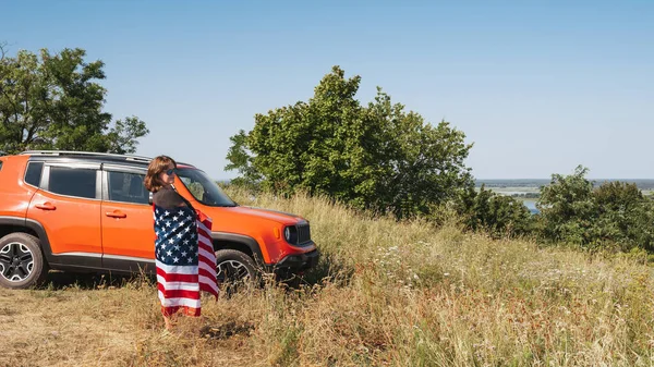Mulher Feliz Com Bandeira América Perto Carro Apreciando Pôr Sol — Fotografia de Stock