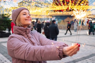 Noel havai fişekleri olan mutlu bir kız. Şehir sokaklarında Noel 'in tadını çıkarıyor..