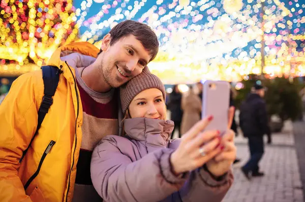 Mutlu gençler Noel günleri dışarıda selfie çekerler. Sevgililer Günü.