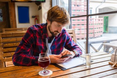 Kovulmuş bir adam elinde telefonla barda tek başına oturuyor. Ekonomik kriz, depresyon, işsizlik.